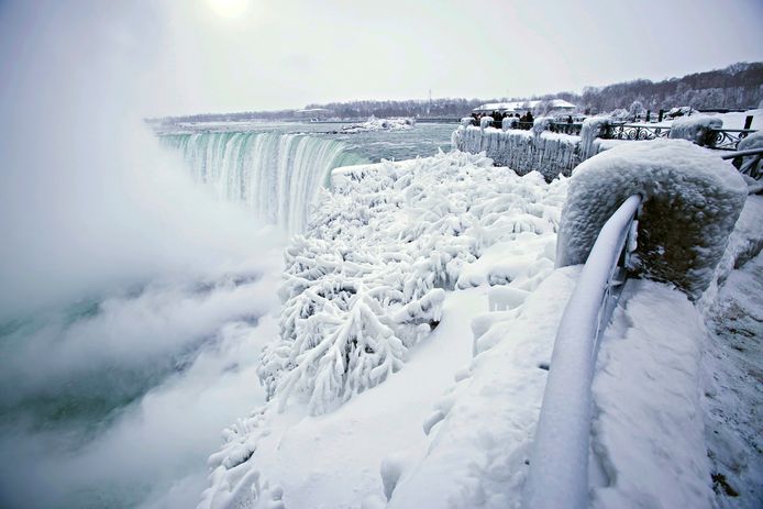 Visitors take photographs at the brink of the Horseshoe Falls in Niagara Falls, Ontario, as cold weather continues through much of the province on Friday, Dec. 29, 2017. (Aaron Lynett/The Canadian Press via AP)