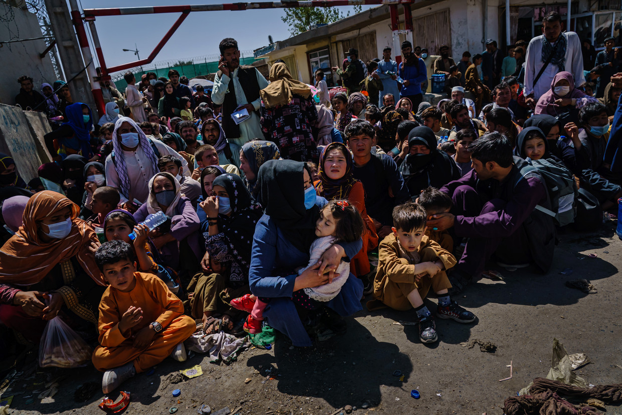 Vrouwen en kinderen moeten wachten bij een checkpoint van de Taliban in de buurt van het vliegveld van Kabul, op 25 augustus 2021.  Beeld Los Angeles Times via Getty Imag