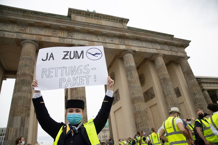 Een werknemer van Lufthansa demonstreert in Berlijn. 'Ja aan het reddingspakket' staat er op het bord geschreven.