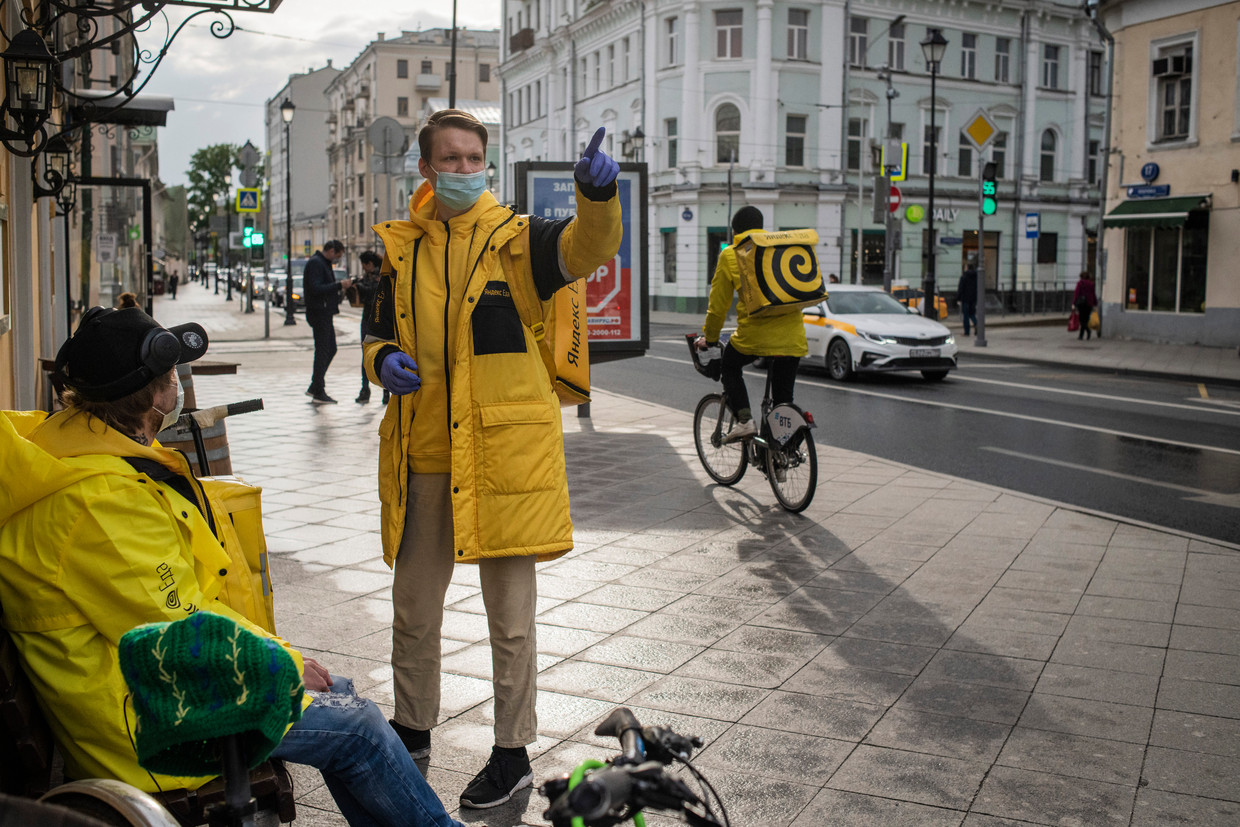 Koeriers van Yandex in Moskou wachten op een nieuwe bestelling. De vraag naar maaltijdbezorging groeide in de lockdown met 75 procent. Beeld Yuri Kozyrev / Noor