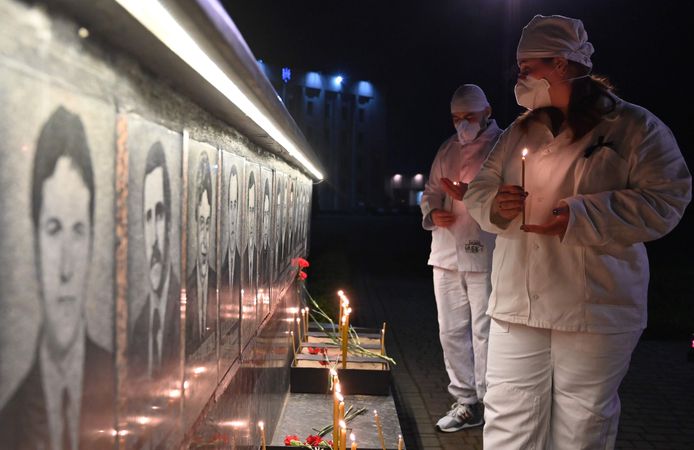 Werknemers van de kerncentrale van Tsjernobyl steken kaarsen aan bij een gedenkteken voor de slachtoffers van Tsjernobyl in Slavoetytsj, een Oekraïense stad 50 kilometer ten noorden van de centrale.