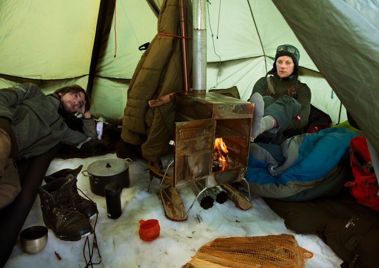 Geologen Lena Håkansson (r) en Alexander Hovland proberen het warm te krijgen in hun tentje op Spitsbergen. Beeld Marte Visser