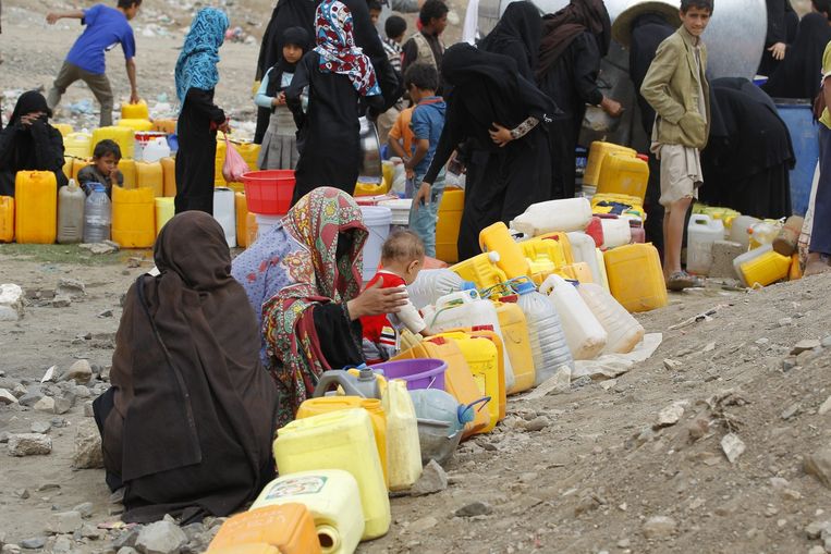 Inwoners van Sanaa vullen jerrycans met water. De watertoevoer in de stad is verstoord vanwege de aanhoudende aanvallen. Beeld anp