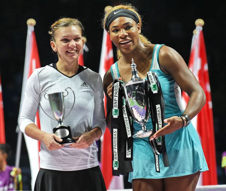 Simona Halep en Serena Williams poseren met hun gewonnen trofeeën. Beeld ANP