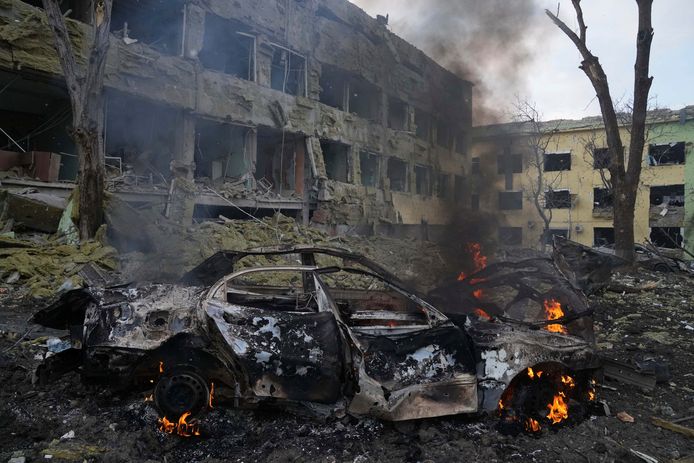 A car burns at the side of the damaged by shelling maternity hospital in Mariupol, Ukraine, Wednesday, March 9, 2022. A Russian attack has severely damaged a maternity hospital in the besieged port city of Mariupol, Ukrainian officials say. (AP Photo/Evgeniy Maloletka)