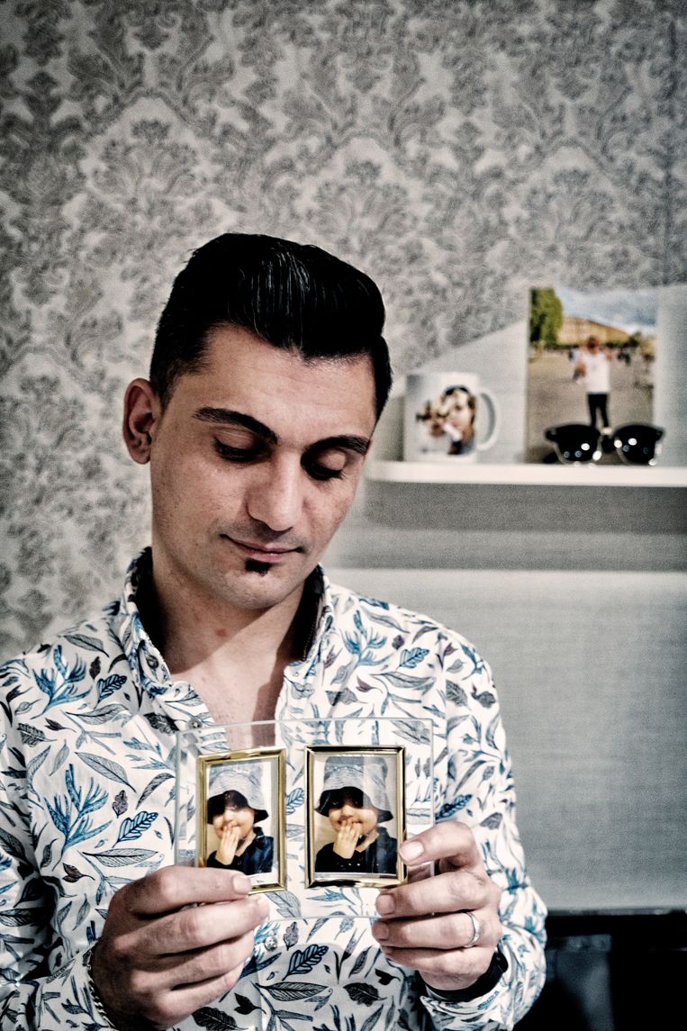 Vader Ali Shamdin met twee foto's van zijn overleden dochter Mawda. ‘Als de agenten kinderen hebben gezien in de bestelwagen, of het nu aan de achterkant was of aan de voorkant, dan denk ik dat ze niet hadden moeten schieten.’ Beeld Tim Dirven