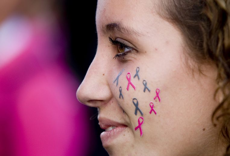 Een meisje met opgeplakte ribbons, het symbool tegen kanker, op haar wang. © ANP Beeld 
