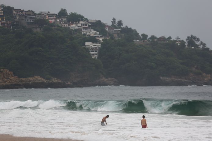 Toeristen zwemmen in de zee bij Acapulco, terwijl de tot orkaan uitgegroeide storm Otis nadert.
