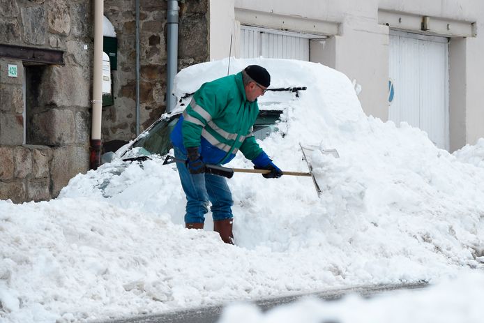 Een man probeert zijn auto sneeuwvrij te maken in Firminy, in het oosten van Frankrijk.