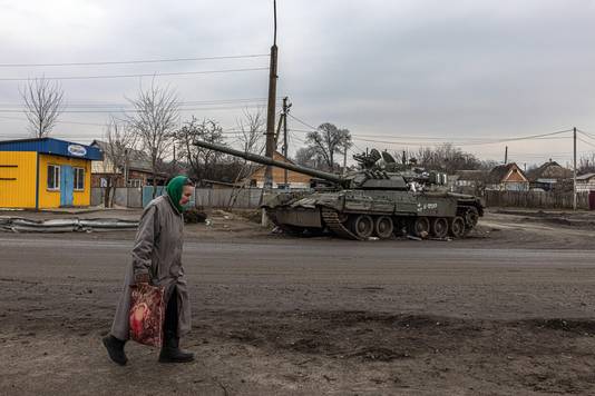 Archieffoto: een vrouw loopt voorbij een beschadigde Russische tank in Trostyanets, in de regio van Soemy. 