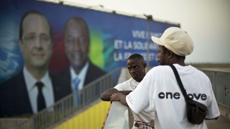 De komst van de Franse president Hollande staat aangekondigd op een groot billboard in Conakry, de hoofdstad van Guinee. Beeld ap