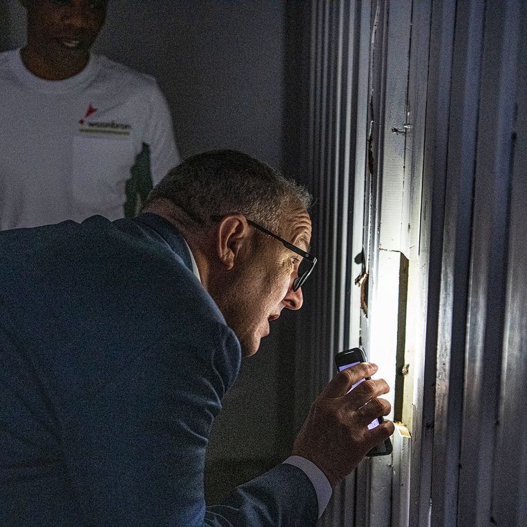 
Burgemeester Ahmed Aboutaleb bekijkt met het lampje van zijn telefoon een kelderbox waar een dakloze woont.
 Beeld Guus Dubbelman / de Volkskrant