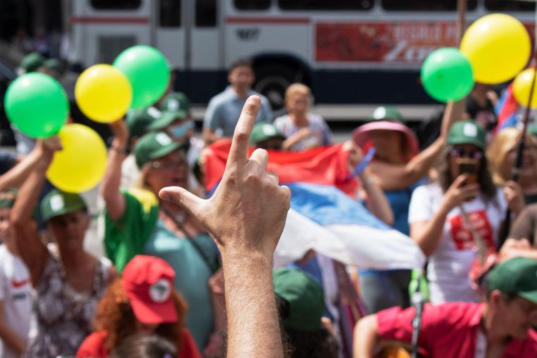 Een aanhanger van de Braziliaanse president Lula da Silva maakt het teken voor 'Lula' tijdens een bezoek van de president aan buurland Uruguay.  Beeld AFP