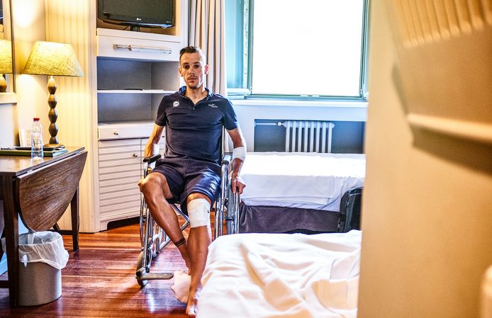 Philippe Gilbert in een rolstoel na zijn zware crash in de Tour de France. De Waal dook een afgrond in tijdens een afdaling, liep stevige averij op aan zijn linkerknie en stond wekenlang aan de kant.