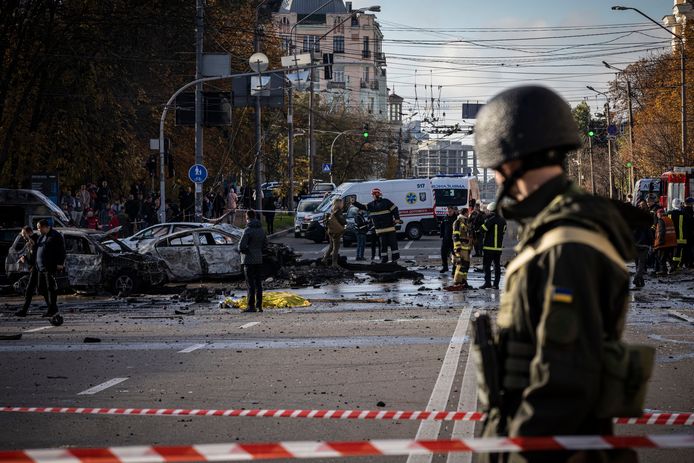 Een soldaat bekijkt de schade op straat in Kiev.