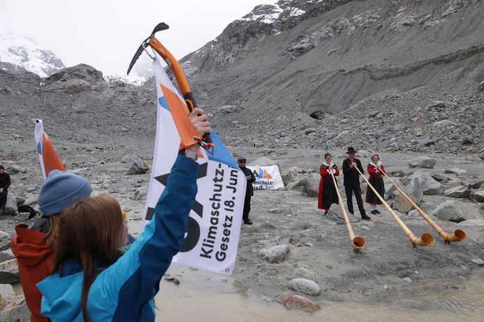 De Zwitsers mogen zich vandaag uitspreken over een nieuwe klimaatwet en hogere belastingen voor bedrijven. Hier demonstreren mensen in klederdracht en met traditionele alpenhoorns op de krimpende gletsjer van Morteratsch voor de nieuwe klimaatwet.