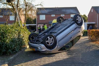 Oudere automobiliste botst tegen lantaarnpaal en belandt op de kop