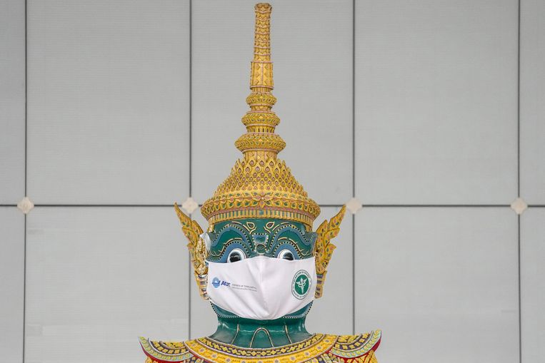 Ook een groot hindoeïstisch Ramayana-standbeeld op het vliegveld van Bangkok draagt een mondkapje. Beeld AP