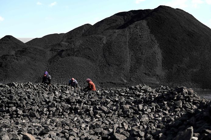 Arbeiders sorteren steenkool bij een kolenmijn in China.