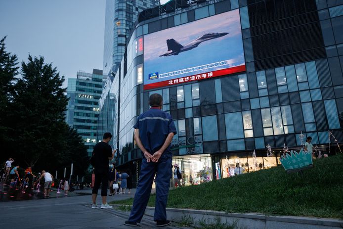 Mensen in Beijing kijken naar een nieuwsuitzending over Chinese militaire operaties in de buurt van Japan.