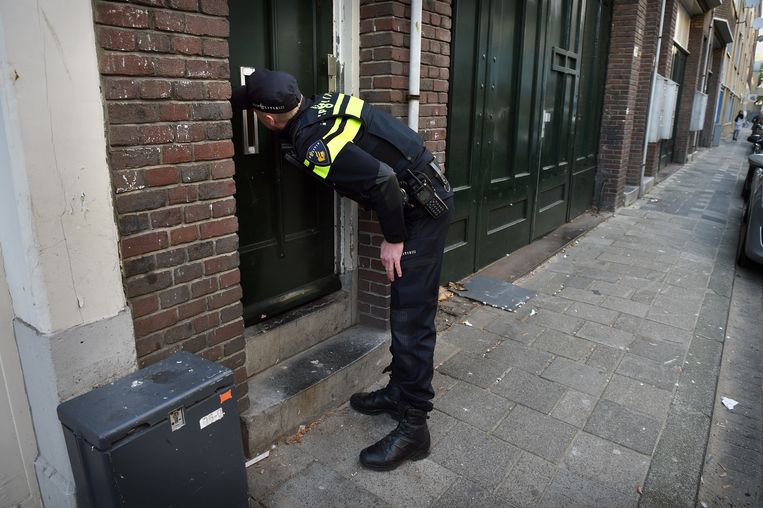 Een wijk agent probeert contact te krijgen met een bewoner in het Oude Westen in Rotterdam. Beeld Marcel van den Bergh / de Volkskrant