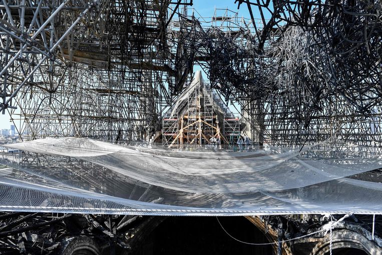 In de beschadigde Notre-Dame in Parijs worden voorbereidingen getroffen om de steigers die voor de brand waren opgebouwd voorzichtig af te breken. Het immense steigerwerk vormt een gevaar voor de wankele resten van de kathedraal. Een 94 meter hoge kraan gaat het materiaal uit de Notre-Dame takelen.  Beeld AFP
