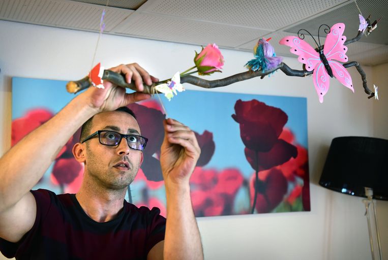 Razi Misté hangt versiering op op de verpleegunit in Beek, waar hij stage loopt.  Beeld Marcel van den Bergh