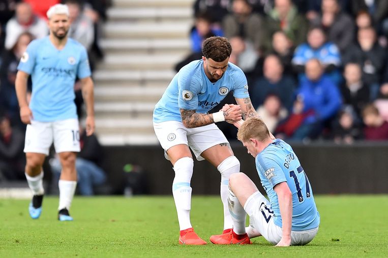 Kyle Walker helpt Kevin De Bruyne overeind. De Belg van Man City is onzeker voor de komende interlands tegen Rusland en Cyprus. Beeld AFP