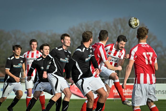 Spelers van Enter (rood wit) en KOSC bij een luchtduel. Thuisploeg KOSC won met 1-0.