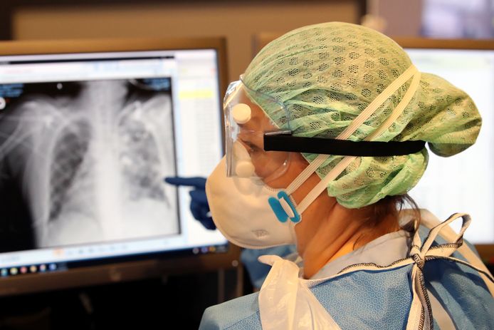 Medisch personeel met een röntgenfoto van de longen van een coronapatiënt in een ziekenhuis in Charleroi.