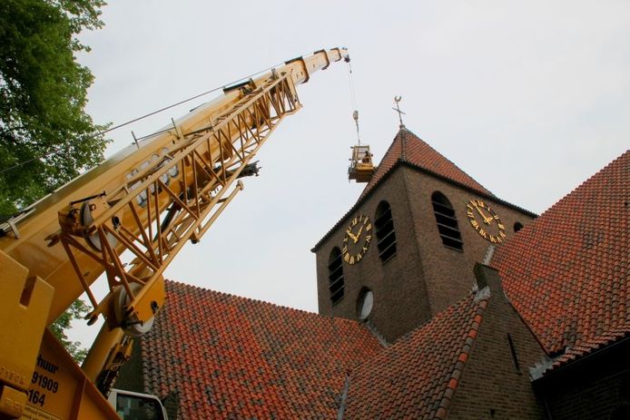 Aan het werk op eenzame hoogte: werknemers van bouwbedrijf Penterman repareren het dak van de toren van de Mattheuskerk in Eibergen. Foto Jelle Boesveld