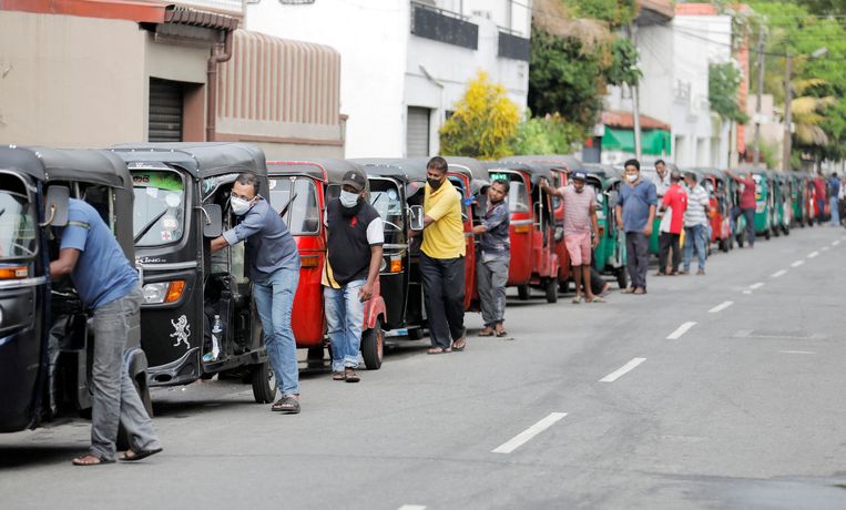 Gigantische files aan de tankstations in Sri Lanka, waar de tuktuk-chauffeurs schaarse brandstof voor hun voertuig hopen te bemachtigen.  Beeld REUTERS