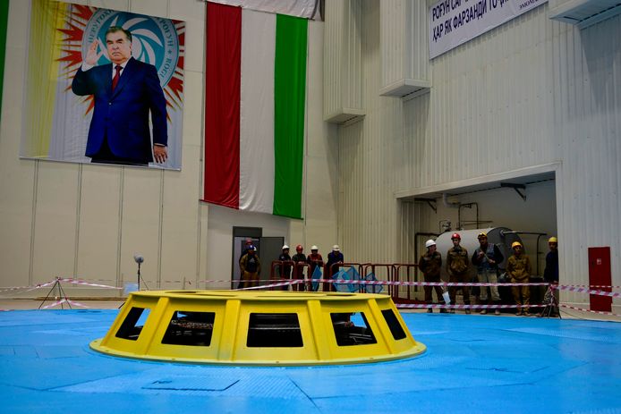 De reusachtige turbinehal met links een beeltenis van  president Rachmon en rechts de vlag van Tadzjikistan.