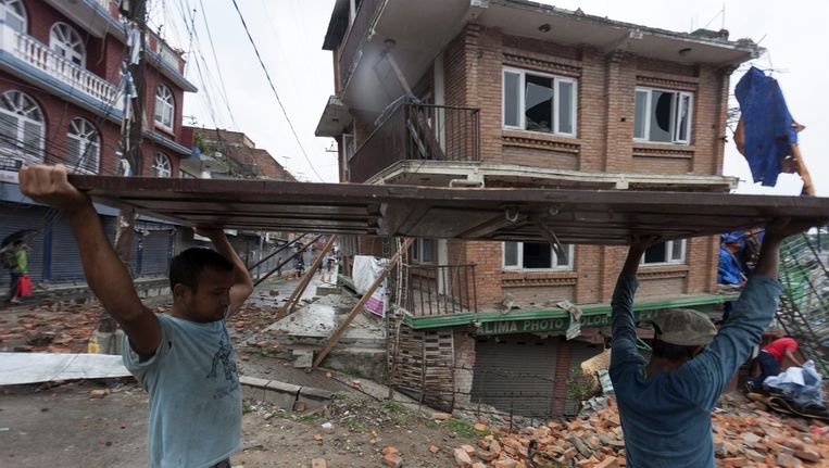 Inwoners van Kathmandu dragen puin na de tweede krachtige aardbeving afgelopen dinsdag in Nepal. Beeld epa