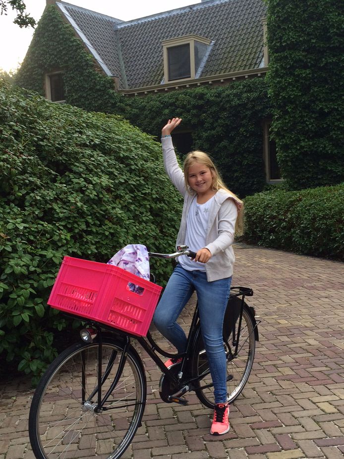 Prinses Amalia zwaait in augustus 2015 als ze op de fiets vanaf Villa Eikenhorst in Wassenaar voor het eerst vertrekt naar haar nieuwe middelbare school, het Christelijk Gymnasium Sorghvliet in Den Haag. De foto is gemaakt door koning Willem-Alexander.