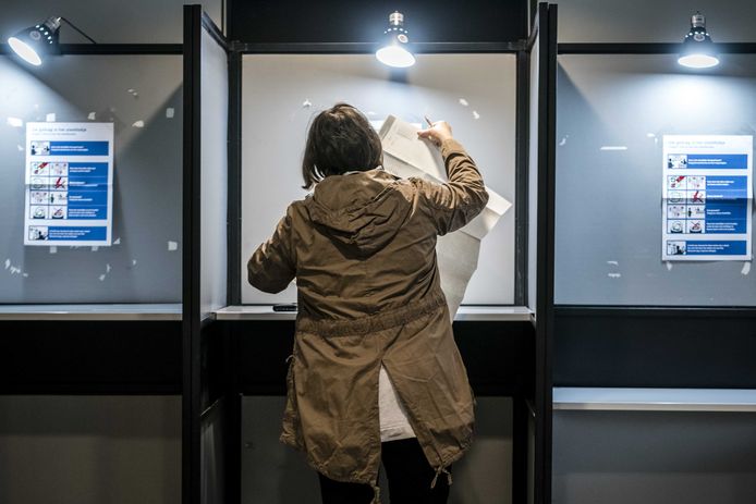 Een vrouw brengt vervroegd haar stem uit in een stemlokaal in Eindhoven. Vanwege de coronapandemie konden kiezers op verschillende plekken ook al op maandag en dinsdag terecht in de stembureaus.