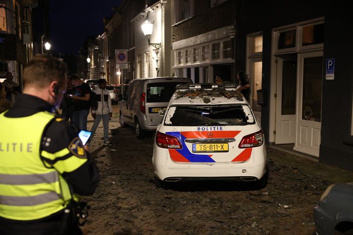 Twee auto's, waaronder deze politiewagen, werden in Kampen vernield door tientallen dakpannen die naar beneden waren gegooid