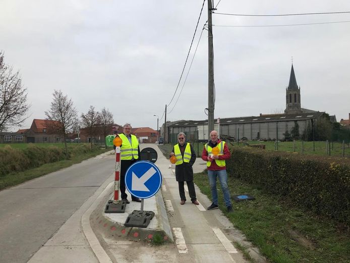 Fractieleider Koen Descheemaeker, penningmeester Marnick Packet en voorzitter Luc Delancker aan de wegversmalling in de richting Zandvoorde, waar vorig weekend een ongeval gebeurde.