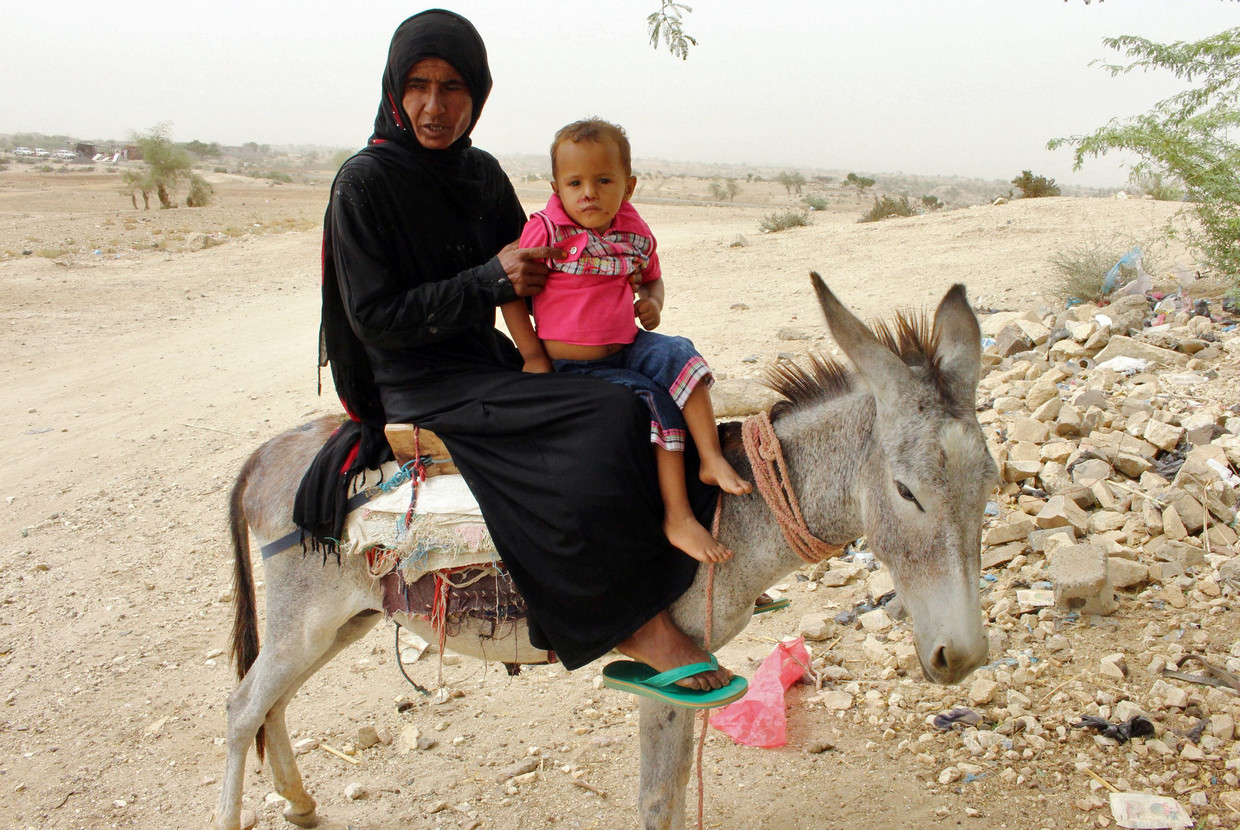 Een vrouw is met haar kind op weg naar een kliniek in Hajjah. Beeld AFP