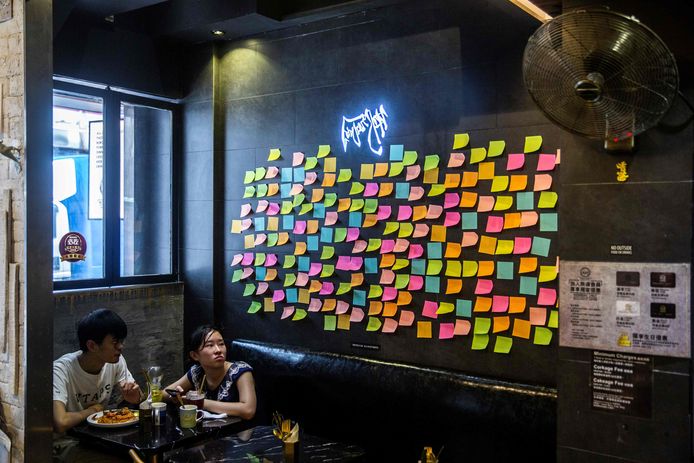 Een wand in een restaurant in Hongkong hangt vol met lege briefjes, een nieuwe vorm van protest tegen de Chinese repressie. Foto ISAAC LAWRENCE / AFP