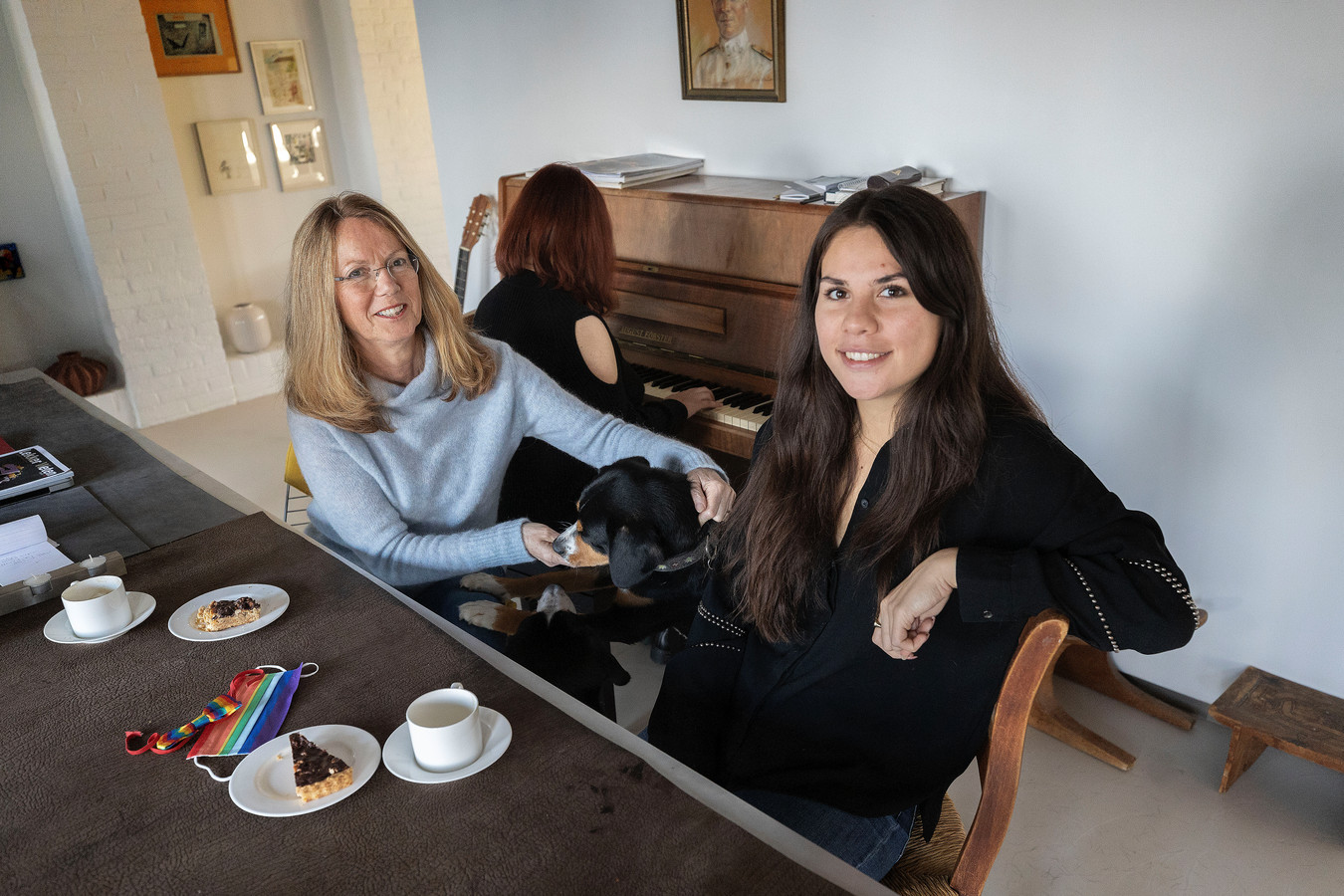 Ria Luichies (l) met dochter Camille. Aan de piano de Georgische asielzoekster ‘Anna’. Ze wacht haar asielaanvraag af bij het gezin in Riethoven.