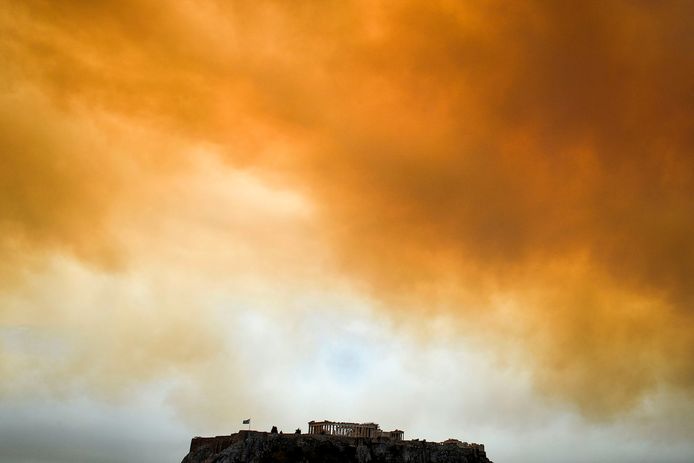 De beroemde Acropolis in Athene wordt omringd door rookwolken.