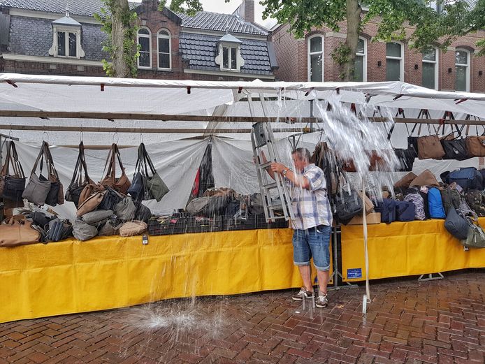 Heel andere problemen in augustus 2018 op de weekmarkt van Oisterwijk: koopman treft met keukentrapje maatregelen na stortbui.