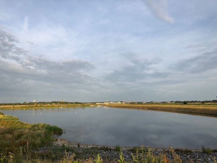 De grote vijver van Battenbroek met in de verte de bedrijven waarvan sprake.