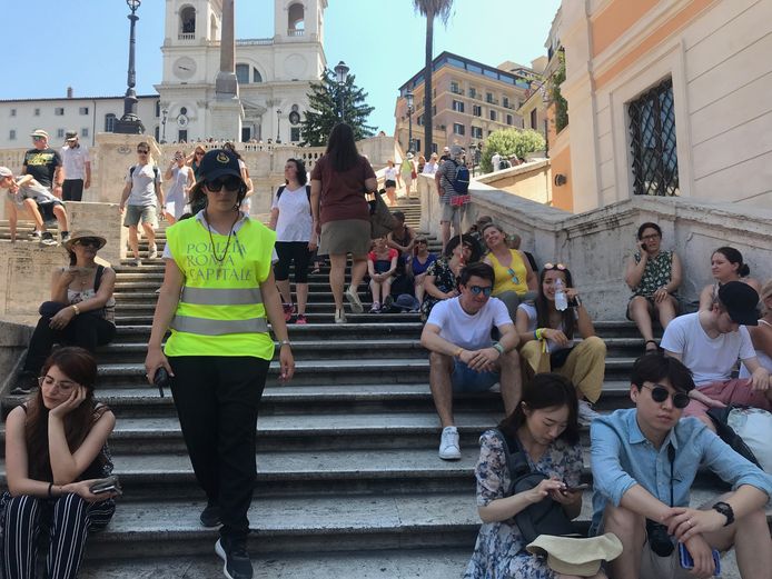 Toeristen op de Spaanse Trappen in Rome; uitrusten mag, eten is uit den boze.