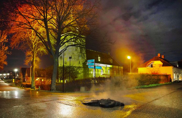 Bij de kerk in Poederoijen smeulen de resten van een buitenbrand na.
