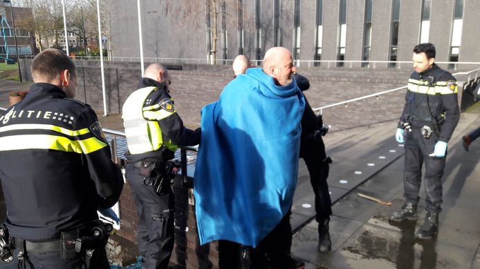 Den Dekker krijgt een deken om zich heen geslagen en wordt aangehouden.