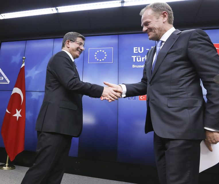 De Turkse premier Davutoglu en de EU-voorzitter Tusk schudden elkaar de hand. Beeld epa