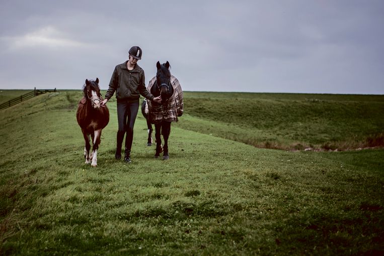Jongedame, lid van de gemeente, brengt paarden - of pony's - terug van de zeedijk naar de stal. Beeld Maarten Boersema