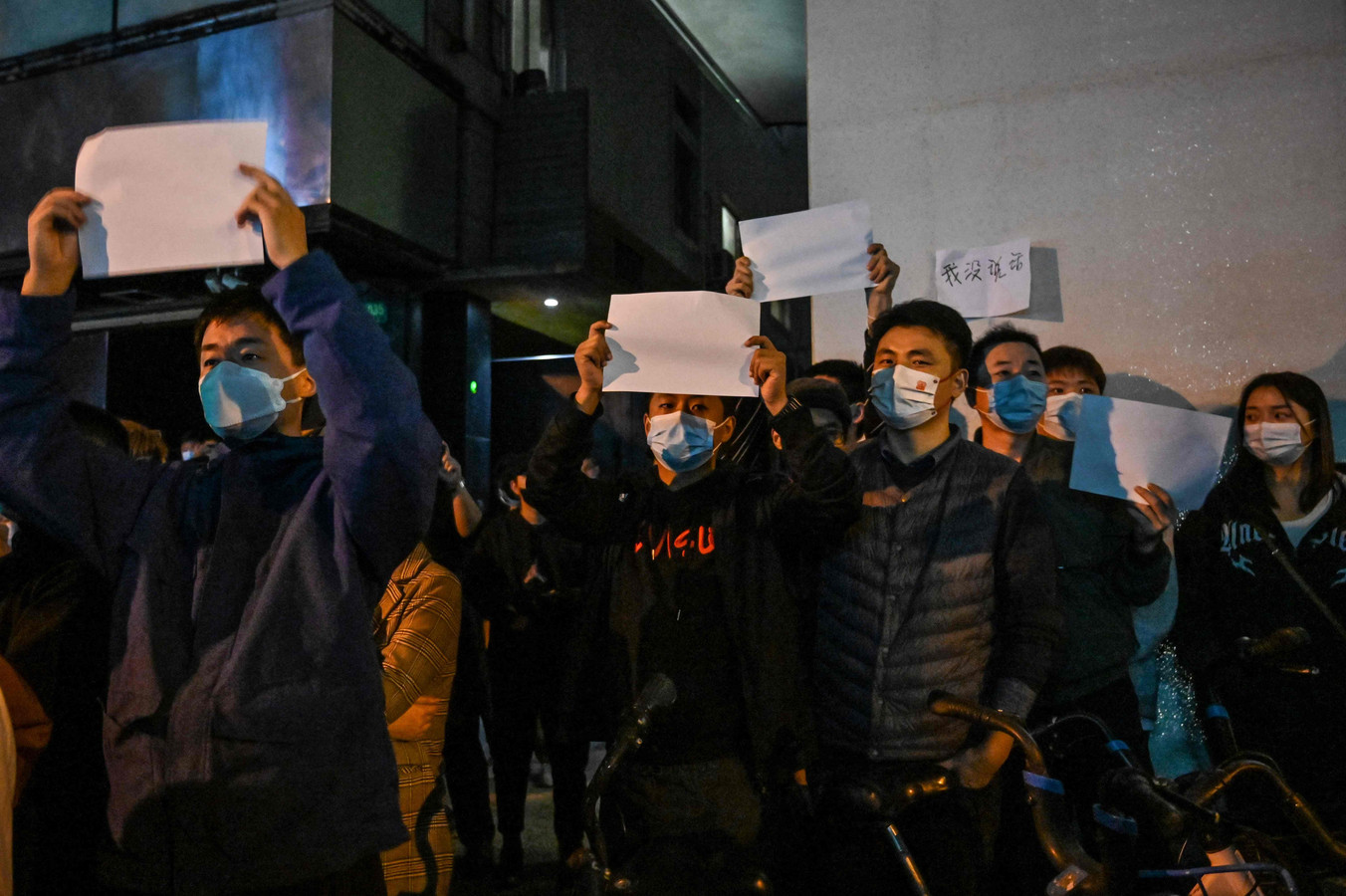 Des manifestants brandissent des feuilles vierges en guise de protestation dans une rue de Shanghai le 27 novembre 2022.